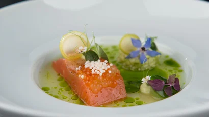 Fein angerichtetes Lachsgericht mit Kräutern und essbaren Blüten