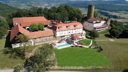 Luftaufnahme eines Landhotels mit Pool in hügeliger Landschaft
