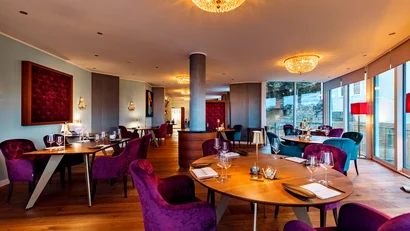 Elegantes Restaurant mit violetten Sesseln und warmem Ambiente