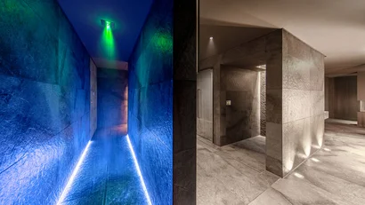 Moderner Spa-Duschbereich mit blauem Licht und grauen Steinwänden