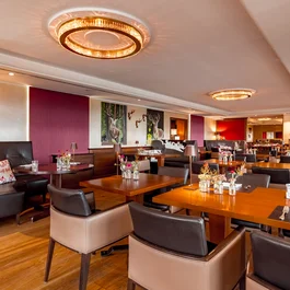 Modernes Restaurant mit Holztischen, Lederstühlen und dekorativen Hirschbildern